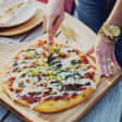 Pizza con bebida frente a la Torre del Oro