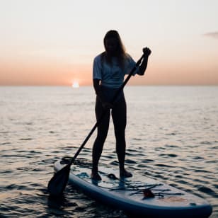 Paddle Surf bei Sonnenaufgang oder Sonnenuntergang in Barcelona